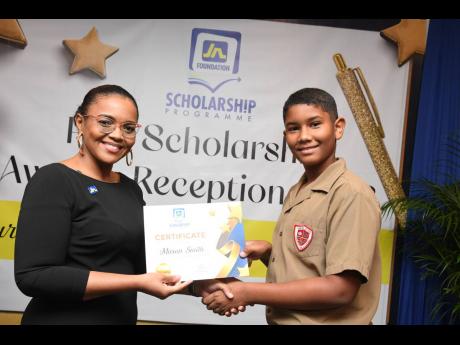 Claudine Allen, general manager of the JN Foundation, presents the 2023 PEP awardee from St Andrew, Mason Smith, with a certificate during the JN Foundation’s PEP Scholarship Awards held at the Summit in New Kingston on November 12 last year.