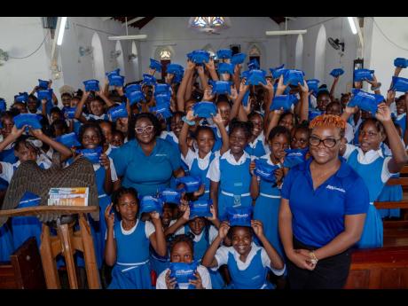 Credit: Contributed Yanique Dixon (left) and Shantaee Lewis, JWN Foundation volunteers pose alongside the girls from the Siloah Primary School, displaying their new sanitary kits courtesy of the JWN Foundation.