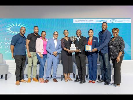 Credit: Contributed Sharing in team NHT’s excitement are; Pearnel Charles Jr. MP, Minister of Labour and Social Security (fourth right) and Dr. Norman Dunn, Minister of State in the Ministry of Labour and Social Security (fourth left). Team NHT include (from left): Ainsley