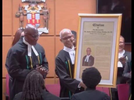Credit: Justice Patrick Brooks, outgoing president of the Court of Appeal, receiving a citation from Chief Justice Bryan Sykes at a special sitting of the Court of Appeal on Wednesday.