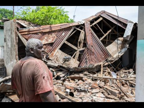 
Fitzroy Ford stands in front of a section of his home which collapsed during the passing of Hurricane Beryl.