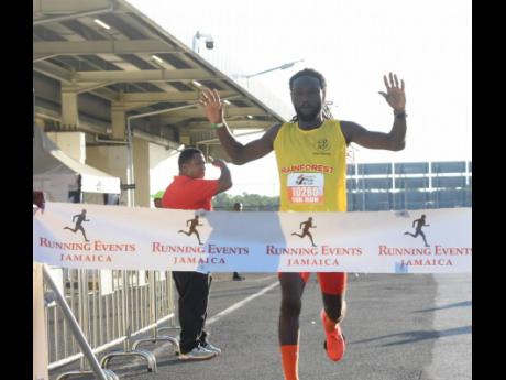 2024 male 10K Run winner at the MBJ  Charity Run/Walk,  Kemar Leslie of Rainforest Seafoods, celebrates after crossing the finish line at the Sangster International Airport in Montego Bay yesterday.