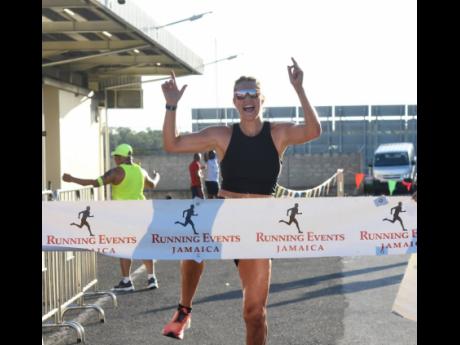 2024 female 10K Run winner at the MBJ  Charity Run/Walk  Tonya Busse celebrates after crossing the finish line at the Sangster International Airport in Montego Bay yesterday.