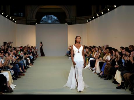 Credit: AP Campbell closed the show in a white gown with a satin bustier and long skirt trailing.