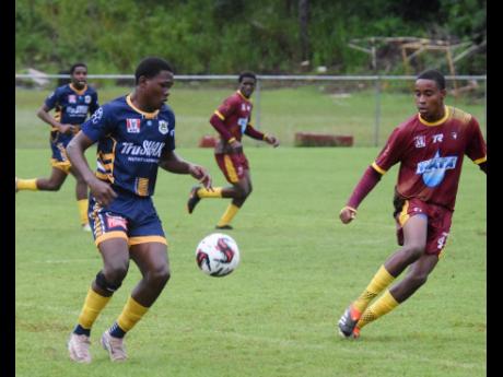 
Munro College’s Akel Vesprey (left) is confronted by Maggotty High’s Trayvon Haughton during their Zone E ISSA/WATA daCosta Cup football match at Munro College on Wednesday.