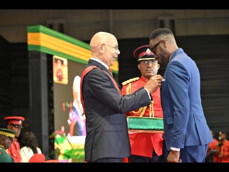 Governor General Sir Patrick Allen presents the Order of Distinction in the rank of Officer to Rodney ‘Bounty Killer’ Price at the National Honours and Awards Investiture Ceremony at the National Indoor Sports Centre on Monday, October 21.