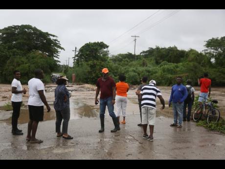 Residents of Race Course and Alley in Clarendon observe as the Alley Bridge became impassable due to floodwaters associated with Tropical Storm Rafael.