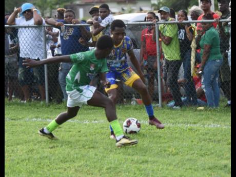 St Elizabeth Technical High School’s Deandre Barnett (right) takes on Frome Technical’s Tavar Cox during their ISSA/WATA daCosta Cup quarterfinal game at the Llandilo Sports Complex in Westmoreland yesterday. 