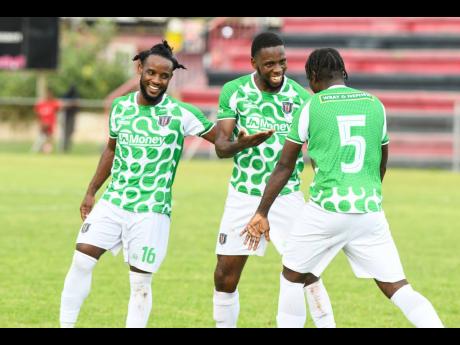 Credit: Matthew McKoy Conaie Rose (left) and Barrington Pryce (right) of Tivoli Gardens celebrate with teammate Kavan Wilson after he scored against Chapelton Maroons during their Jamaica Premier League match at the Anthony Spaulding Sports Complex, yesterday.