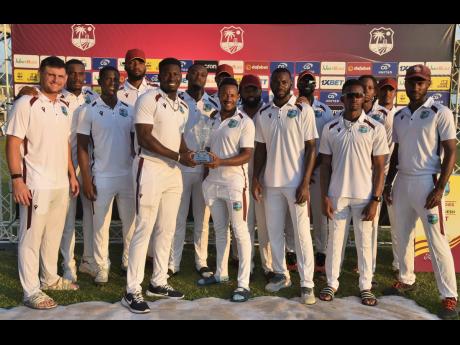 West Indies’ Test team poses with the trophy shared with Bangladesh after a 1-1 tie in a series in the Caribbean at Sabina Park on December 3.