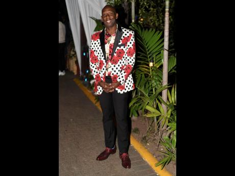 Credit: Antoine Lodge Hugh Graham, chief executive officer, Paramount Trading, dons a vibrant Italian printed tuxedo jacket, pairing it with black pants and a floral shirt.