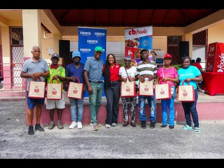 Credit: Contributed Karl Whyte (fourth from left), councillor, South Western St Elizabeth, and Nicole Hall (fifth from left), commercial marketing manager, CB Foods, along with recipients of the PAN Christmas Giveback Initiative, pose for a photo at the Black River Preparator