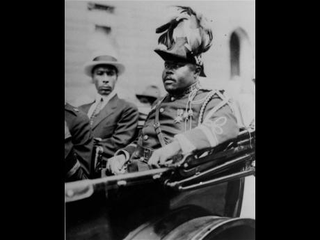 In this August 1922 file photo, Marcus Garvey (right), is shown in a military uniform as the ‘Provisional President of Africa’ during a parade on the opening day of the annual Convention of the Negro Peoples of the World along Lenox Avenue in Harlem, N