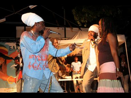Credit: File Determine (left) competes with Fantan Mojah (centre) to serenade Pashon Minott at her birthday bash on Saturday, April 8, 2006.