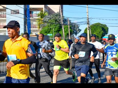 Credit: Matthew McKoy/Photographer Prime Minister Dr Andrew Holness (centre) surrounded by his security team as he runs toward the finish line during the Sagicor Sigma Run 2025 held in New Kingston yesterday.