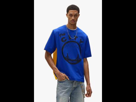 Credit: Contributed SAINT International star Romaine Dixon is one of the faces of the new Hardwood Classics e-comm collection—a collaboration between Purple Brand, the National Basketball Association (NBA), and Mitchell & Ness. He is pictured here wearing a mesh tee represe