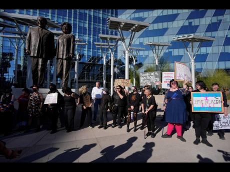 Credit: AP Protestors hold signs during a rally for a nationwide economic blackout last Wednesday in Las Vegas