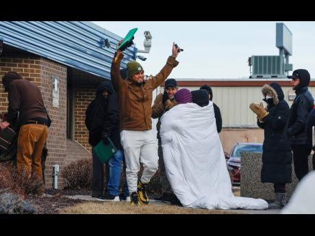 Credit: AP A man waves to cheering supporters after coming out of the US Immigration and Customs Enforcement office following his immigration check-in in Cedar Rapids, Iowa on February 4.