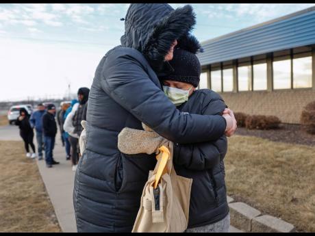 Credit: AP Jonna Higgins-Freese (left), of Iowa City, Iowa, hugs a woman waiting for her immigration check-in outside of the US Immigration and Customs Enforcement office in Cedar Rapids, Iowa on February 4.