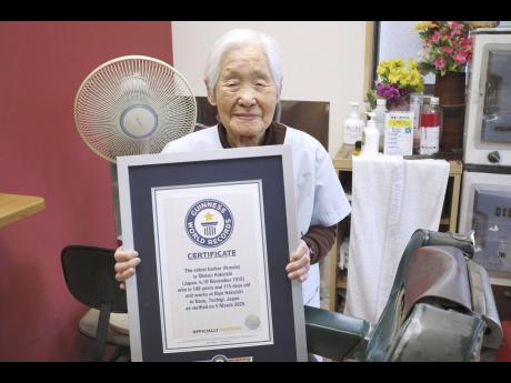 Shitsui Hakoishi poses for a photo with a Guinness World Records certificate recognising her as the world’s oldest female barber, at her shop in Nakagawa in Tochigi Prefecture, eastern Japan, on Wednesday, March 5.