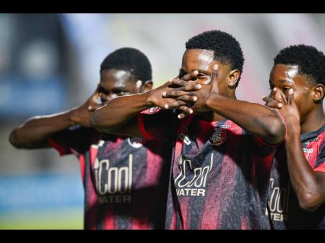 Credit: Matthew McKoy From left: Arnett Gardens’ Rushane Thompson celebrates a goal against Molynes United with teammates Ricardo Thomas, and Kivann Salmon at the Waterhouse Stadium yesterday.