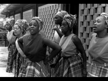 Credit: Gleaner Photo In this 1983 file photo, Olive Lewin (arms akimbo) leads the women of the Jamaican Folk Singers in one of the many songs they will perform in the Easter Day Concert at St. Barnabas Church, Siloah, on April 3 at 4:00 pm.