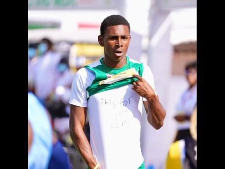 
William Knibb High School’s Sanjay Seymore displays an undershirt with the message “This, for you Pops” after winning the Class One 200 metres at the ISSA/GraceKenedy Boys and Girls’ Athletics Championships at the National Stadium yesterday.