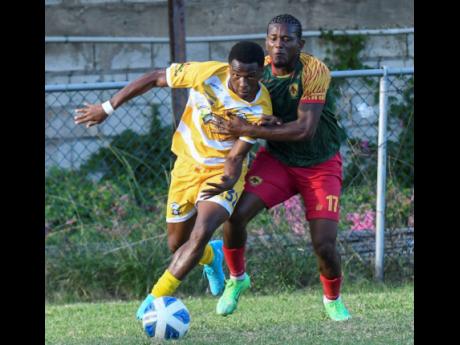 Credit: Antoine Lodge Devone Davis (left) of Molynes United dribbles past Humble Lions’ Stephen Barnett during their Jamaica Premier League match at the Waterhouse Mini Stadium, yesterday. The game ended in a 1-1 draw.