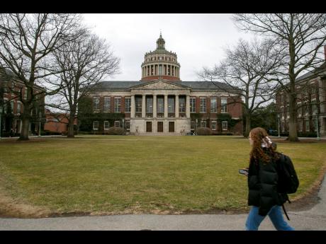 Credit: Ted Shaffrey A student walks by the Rush Rhees Library at the University of Rochester, February 22, 2023. (AP Photo/Ted Shaffrey, File)