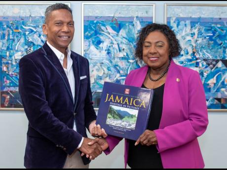 Cricket West Indies Chief Executive Officer Chris Dehring is presented with a book during an official visit to Minister of Culture, Gender, Entertainment and Sport Olivia Grange on Monday. 