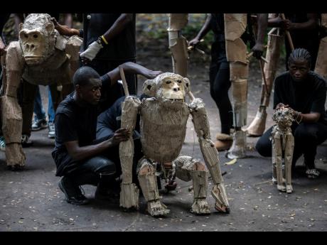 Credit: AP Puppeteers move cardboard animals through DRC’s capital Kinshasa’s botanical gardens last Thursday, the first steps of ‘The Herds’, a moving theatre performance that will travel from the Democratic Republic of the Congo to the Arctic Circle in a bi