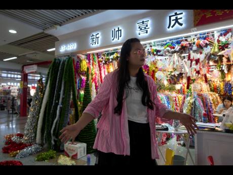 Credit: Ng Han Guan Ding Dandan, who runs Christmas decorations exports, speaks outside her store at the Yiwu International Trade Market in Yiwu, eastern China’s Zhejiang province on Thursday, April 10, 2025. (AP Photo)