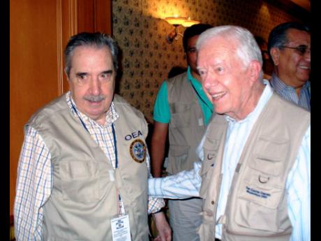 Credit: File In this 2006 photo, Jimmy Carter (right) and Gustavo Fernández are seen with their respective teams from the Carter Center and the Electoral Observation Mission of the Organization of American States which observed the country’s presidential elections i