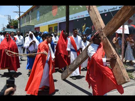 Credit: Ian Allen Members of Missionaries of the Poor re-enact Crucifixion of Christ along Wildman Street in Central Kingston on Good Friday.