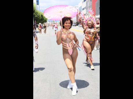 Costume and fashion designer Kris Jackson dons her own creation, adding a parasol for a touch of flair and protection. 