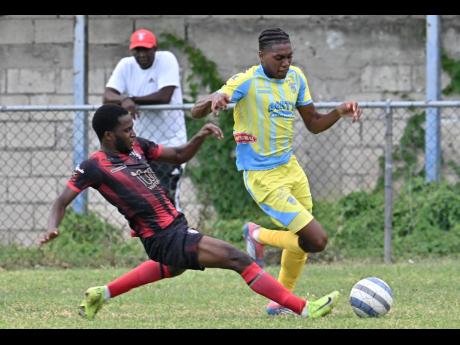 Credit: Rudolph Brown Rushike Kelson (left) of Arnett Gardens slides in to tackle Ky-Mani Campbell of Waterhouse during yesterday’s Jamaica Premier League match at the Waterhouse Mini Stadium.