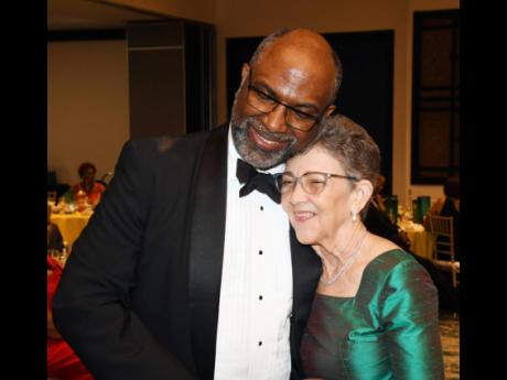 Credit: Contributed Earl Jarrett, chief executive officer of The Jamaica National Group, hugs Elizabeth Ann Jones, chairman of The Jamaica National Group, after she received the Institute of Chartered Accountants of Jamaica’s 2024 Distinguished Member Award at the Institut