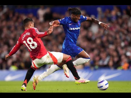 Manchester United’s Casemiro (left) challenges Chelsea’s Noni Madueke during their English Premier League footall match at Stamford Bridge, London, yesterday.
