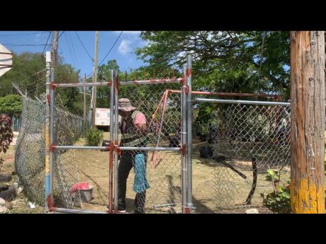A workman repairing the perimeter fence at the Cornwall Court ‘kiddies park’.