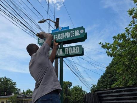 Credit: Contributed Contractor putting up corrected Shelly-Ann Fraser-Pryce Drive sign.