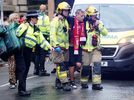Police and emergency personnel deal with an incident on Water Street near the Liver Building in Liverpool after a car collided with pedestrians during the Premier League winners parade, in Liverpool, England, Monday May 26, 2025. (Owen Humphreys/PA via AP)