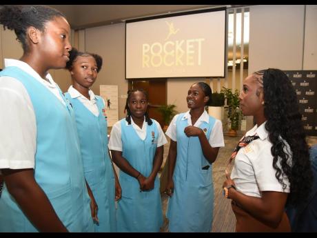 Credit: Ian Allen Shelly-Ann Fraser-Pryce (right), founder and chairwoman, The Pocket Rocket Foundation, speaks with students from her alma mater, Wolmer’s High School for Girls, during the Pocket Rocket Foundation Student-Athletes Summit at the AC Hotel in Kingston, yest