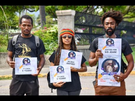 Protesters (from left) Zaken, Iyansa, and Abijah ‘Naki Wailer’ Livingston, son of the late Bunny Wailer, stand in solidarity outside the Criminal Investigations Branch in St Andrew on Monday, as they mark five years since the mysterious disappearance o