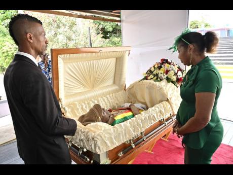 Credit: Rudolph Brown Junior Byles’s sister, Vivienne, takes one last look on her brother at his thanksgiving service at the Louise Bennett Garden Theatre on Hope Road on Monday.