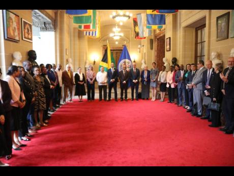 Ambassador Antony Anderson, the permanent representative of Jamaica to the Organization of American States (OAS), is flanked by the OAS leadership including Secretary General Albert Ramdin to his left and Assistant Secretary General Nestor Mendez to his ri