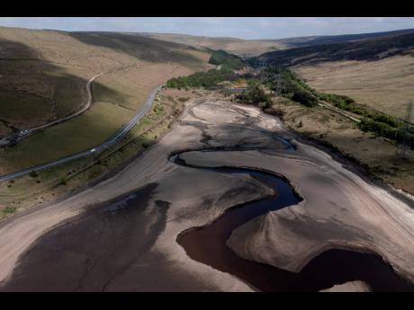Credit: AP Low water levels are visible at Woodhead Reservoir in Derbyshire as the area experiences a significant drought, in Woodhead, England, in May.