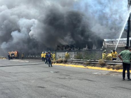 Firefighters battling a massive blaze at a warehouse storing various chemicals on Spanish Town Road in St Andrew on Monday.