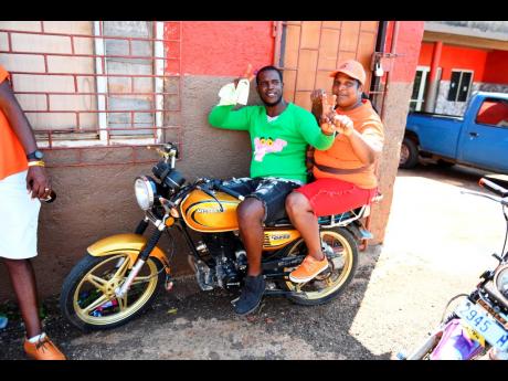 PNP and JLP supporters are seen on a bike in Plowden, Manchester, during the local government elections in February 2024.