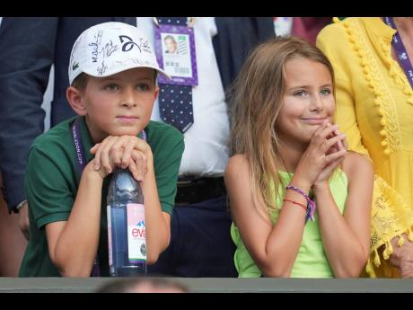 Stefan and Tara, the children of Serbia’s Novak Djokovic, smile after their father beat Italy’s Flavio Cobolli in a quarter-final men’s singles match at the Wimbledon Tennis Championships in London yesterday.