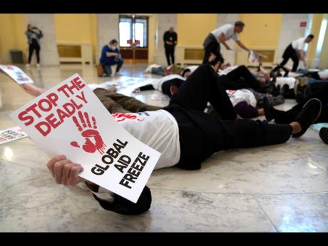 Demonstrators protest against cuts to American foreign aid spending, including USAID and the PEPFAR program to combat HIV/AIDS, at the Cannon House Office Building on Capitol Hill, Wednesday, February 26, 2025, in Washington. 